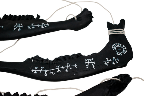 Image of blackened jawbone hanger to prevent harm from pets and livestock